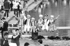 10月2日，湘西凤凰古城，游客身穿民族服装拍合影留念。